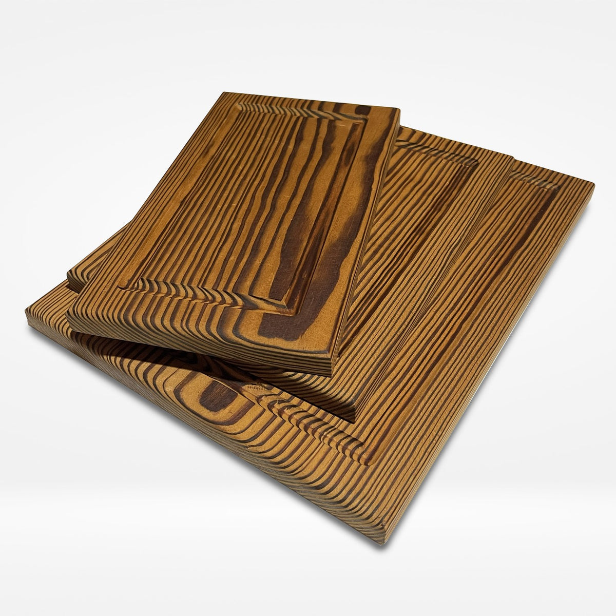 Kit de tres tablas de picar de PuraMadera en pino termotratado, apiladas sobre fondo claro