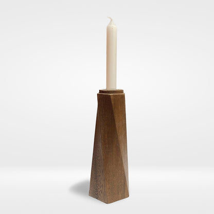 Portavelas Tornado de PuraMadera, columna facetada de roble, con una vela encendida sobre fondo claro